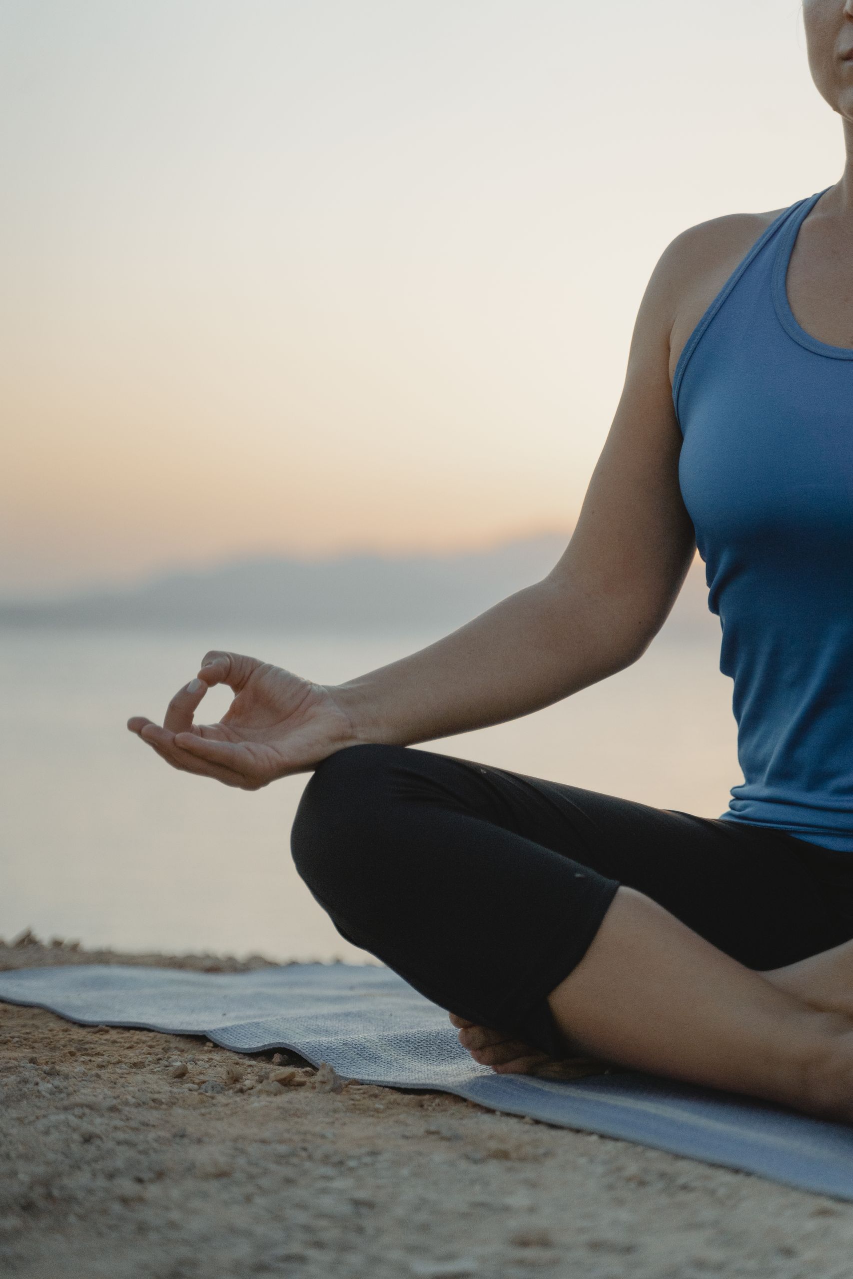 Femme qui pratique le yoga au coucher du soleil